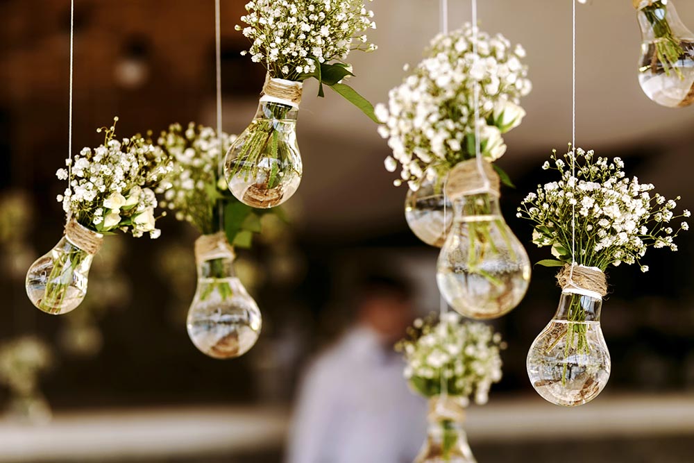 How Much Does a Professional Wedding Decorator Cost? https://www.shutterstock.com/image-photo/original-wedding-floral-decoration-form-minivases-354527417 Some people have a gift for creating an elegant ambiance, and others, like myself simply do not. And while your main memory of your wedding will be about your exchange of heart-felt vows, what your guests will remember is all the nice details. You should give them something to remember your wedding day as long as you will. But, do you really want to hire a wedding decorator? On the one hand you can be assured of a stunning venue, but on the other hand, you have to consider the cost. There are several expenses that go into making the perfect wedding, and do you really want to add to it by hiring a wedding decorator if you can get away with not doing it? To help you answer these questions, in this article, we’re going to look at what a wedding decorator is and what they actually do. Then we’re going to dive into the pros and cons of hiring a wedding, before covering the average cost of hiring a wedding decorator. At the end of the article, we’ll sign off with a brief conclusion. (Please feel free to scroll ahead to any section that interests you.) What Is A Wedding Decorator? What Do They Do? https://www.shutterstock.com/image-photo/happy-young-businesswoman-wearing-earphones-enjoying-1801130773 As the name suggests, it is the job of a wedding decorator to decorate your wedding venues, from the wedding ceremony itself through to the meal and the evening bash. What does a wedding decorator do? But as to what exactly that entails depends on the wedding decorator you have chosen… Some wedding directors will expect you to have some general ideas about what you want in terms of color schemes or themes. They may even expect you to pay for all the decorations yourself in addition to their fee. Other wedding decorators on the other hand will suggest various ideas to you, and include the price of the wedding decorations in their bill. Some wedding decorators will be concerned about the overall concepts, making sketches and coming up with design ideas. But some wedding decorators are a lot more hands-on, and will physically be involved in putting up the decorations. https://www.shutterstock.com/image-photo/wedding-decor-sketch-on-paper-scissors-313574144 Important Note But it’s important to not go into a contract blindly. When you first speak to a wedding director for a quote, be sure to ask what is and isn’t covered by their fee. That way you will know well in advance whether you will have to pay separately for the decorations themselves, and you won’t be met with a surprise bill to pay. You should also gauge from the wedding director how much of a say you will get in the decoration arrangements and, similarly, discuss how much lee way you’re prepared to give. On The Day The wedding decorator will be there on the big day, making sure that everything is as it should be. Perfect. They may work alone, or more likely, have a small team to help set up the furniture and decor. But there may still be some final touches that will have to be organised by the members of the wedding party, such as placing of the name plates etc. https://www.shutterstock.com/image-photo/close-female-hands-that-sets-candles-1055900117 Important Note But before you do go looking for a wedding decorator, you must first check with your wedding venue whether they will accept outside decorators to come in and make the arrangements. Sometimes a venue will not allow this because they want to push for use of their own services. If your chosen wedding decorator does not have a team for setting everything up on the day, then you can often hire help by the hour, and your venue’s in-house vendors will be the most convenient team to look into. Advantages and Disadvantages of Hiring a Wedding Decorator If you’re still in two minds whether to hire a wedding decorator, something that can really help you to decide is a simple list of advantages versus the disadvantages. Advantages There’s quite a lot to plan when it comes to weddings, and any removal of some of these responsibilities from those organizing it can often come as a huge relief… It frees up the organizers to concentrate on things which may be of greater concern, such as the wording of the vows, the catering or menu options, the entertainment and the first dance. Also we’re not all gifted with the midas touch, and however glorious your decoration ideas may look in your head, it’s quite another thing to actually make it happen. If you hire a professional to take care of it, you can rest assured that you’ll be in good hands, and that your wedding will look as beautiful as it feels. Besides, getting someone else to take care of the decorations, gives you more free time to simply enjoy the day and not get caught up in unnecessary details. Moreover, before you book a wedding decorator, you will be able to view their portfolio, and this is great because it means you can see an array of what the decorator is capable of, and see for yourself whether their tastes align well with yours. Disadvantages We’re going to level with you here. The biggest drawback to hiring a wedding decorator is the cost. (More on that very shortly.) Some wedding decorators like to go all out if they can, with big expensive decorations, and a large team to employ. Weddings can be very expensive affairs as it is, and you could argue that the job of a paid wedding decorator is one that you simply don’t need, especially if your venue has offered its manual in-house services. The Cost of Hiring a Wedding Decorator https://www.shutterstock.com/image-photo/wedding-set-657654997 So, let’s get down to the nitty gritty - how much does a wedding decorator actually cost? The truth is this depends on a number of factors. For example, wedding decorators are more expensive in high income areas than in lower income areas. And another influence on the cost is whether your wedding decorator will charge one flat rate in some sort of package deal. Or whether they will charge an hourly rate. With a package deal you have the advantage of knowing the final cost beforehand, but with an hourly rate, you may get some additional costs as issues crop up and have to be addressed. According to Fash.com, the average cost of hiring a wedding decorator across the United States usually falls between $550 and $800. But this range doesn’t reflect the entire spectrum of wedding decorator costs, and some packages can cost about $1500. The exact cost will vary depending on such things as the number of guests. A smaller event will require less decorating work. Conclusion We would argue that hiring a wedding decorator can be worth it if you have the budget to do so. However, be sure to do your homework before signing a contract. How Much Does a Professional Wedding Decorator Cost? https://www.shutterstock.com/image-photo/original-wedding-floral-decoration-form-minivases-354527417 Some people have a gift for creating an elegant ambiance, and others, like myself simply do not. And while your main memory of your wedding will be about your exchange of heart-felt vows, what your guests will remember is all the nice details. You should give them something to remember your wedding day as long as you will. But, do you really want to hire a wedding decorator? On the one hand you can be assured of a stunning venue, but on the other hand, you have to consider the cost. There are several expenses that go into making the perfect wedding, and do you really want to add to it by hiring a wedding decorator if you can get away with not doing it? To help you answer these questions, in this article, we’re going to look at what a wedding decorator is and what they actually do. Then we’re going to dive into the pros and cons of hiring a wedding, before covering the average cost of hiring a wedding decorator. At the end of the article, we’ll sign off with a brief conclusion. (Please feel free to scroll ahead to any section that interests you.) What Is A Wedding Decorator? What Do They Do? https://www.shutterstock.com/image-photo/happy-young-businesswoman-wearing-earphones-enjoying-1801130773 As the name suggests, it is the job of a wedding decorator to decorate your wedding venues, from the wedding ceremony itself through to the meal and the evening bash. What does a wedding decorator do? But as to what exactly that entails depends on the wedding decorator you have chosen… Some wedding directors will expect you to have some general ideas about what you want in terms of color schemes or themes. They may even expect you to pay for all the decorations yourself in addition to their fee. Other wedding decorators on the other hand will suggest various ideas to you, and include the price of the wedding decorations in their bill. Some wedding decorators will be concerned about the overall concepts, making sketches and coming up with design ideas. But some wedding decorators are a lot more hands-on, and will physically be involved in putting up the decorations. https://www.shutterstock.com/image-photo/wedding-decor-sketch-on-paper-scissors-313574144 Important Note But it’s important to not go into a contract blindly. When you first speak to a wedding director for a quote, be sure to ask what is and isn’t covered by their fee. That way you will know well in advance whether you will have to pay separately for the decorations themselves, and you won’t be met with a surprise bill to pay. You should also gauge from the wedding director how much of a say you will get in the decoration arrangements and, similarly, discuss how much lee way you’re prepared to give. On The Day The wedding decorator will be there on the big day, making sure that everything is as it should be. Perfect. They may work alone, or more likely, have a small team to help set up the furniture and decor. But there may still be some final touches that will have to be organised by the members of the wedding party, such as placing of the name plates etc. https://www.shutterstock.com/image-photo/close-female-hands-that-sets-candles-1055900117 Important Note But before you do go looking for a wedding decorator, you must first check with your wedding venue whether they will accept outside decorators to come in and make the arrangements. Sometimes a venue will not allow this because they want to push for use of their own services. If your chosen wedding decorator does not have a team for setting everything up on the day, then you can often hire help by the hour, and your venue’s in-house vendors will be the most convenient team to look into. Advantages and Disadvantages of Hiring a Wedding Decorator If you’re still in two minds whether to hire a wedding decorator, something that can really help you to decide is a simple list of advantages versus the disadvantages. Advantages There’s quite a lot to plan when it comes to weddings, and any removal of some of these responsibilities from those organizing it can often come as a huge relief… It frees up the organizers to concentrate on things which may be of greater concern, such as the wording of the vows, the catering or menu options, the entertainment and the first dance. Also we’re not all gifted with the midas touch, and however glorious your decoration ideas may look in your head, it’s quite another thing to actually make it happen. If you hire a professional to take care of it, you can rest assured that you’ll be in good hands, and that your wedding will look as beautiful as it feels. Besides, getting someone else to take care of the decorations, gives you more free time to simply enjoy the day and not get caught up in unnecessary details. Moreover, before you book a wedding decorator, you will be able to view their portfolio, and this is great because it means you can see an array of what the decorator is capable of, and see for yourself whether their tastes align well with yours. Disadvantages We’re going to level with you here. The biggest drawback to hiring a wedding decorator is the cost. (More on that very shortly.) Some wedding decorators like to go all out if they can, with big expensive decorations, and a large team to employ. Weddings can be very expensive affairs as it is, and you could argue that the job of a paid wedding decorator is one that you simply don’t need, especially if your venue has offered its manual in-house services. The Cost of Hiring a Wedding Decorator https://www.shutterstock.com/image-photo/wedding-set-657654997 So, let’s get down to the nitty gritty - how much does a wedding decorator actually cost? The truth is this depends on a number of factors. For example, wedding decorators are more expensive in high income areas than in lower income areas. And another influence on the cost is whether your wedding decorator will charge one flat rate in some sort of package deal. Or whether they will charge an hourly rate. With a package deal you have the advantage of knowing the final cost beforehand, but with an hourly rate, you may get some additional costs as issues crop up and have to be addressed. According to Fash.com, the average cost of hiring a wedding decorator across the United States usually falls between $550 and $800. But this range doesn’t reflect the entire spectrum of wedding decorator costs, and some packages can cost about $1500. The exact cost will vary depending on such things as the number of guests. A smaller event will require less decorating work. Conclusion We would argue that hiring a wedding decorator can be worth it if you have the budget to do so. However, be sure to do your homework before signing a contract.